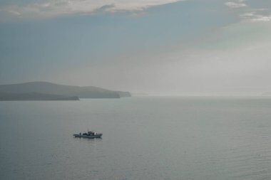 Kayaların, uçurumların, gün batımında dağların arasında Baykal Gölü 'nde gemi