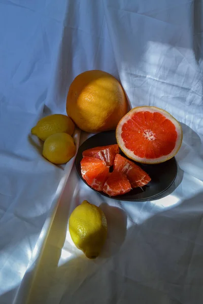 Avskårne Røde Oransje Grapefrukt Tallerkenen Gule Sitroner Hvitt Draperi Med – stockfoto