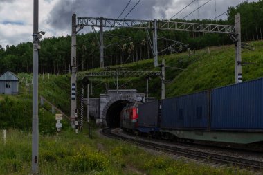 Tren yolu, tren yolu yeşil dağlarda bir tünelle ağaçlar, teller, gökyüzünde bulutlar