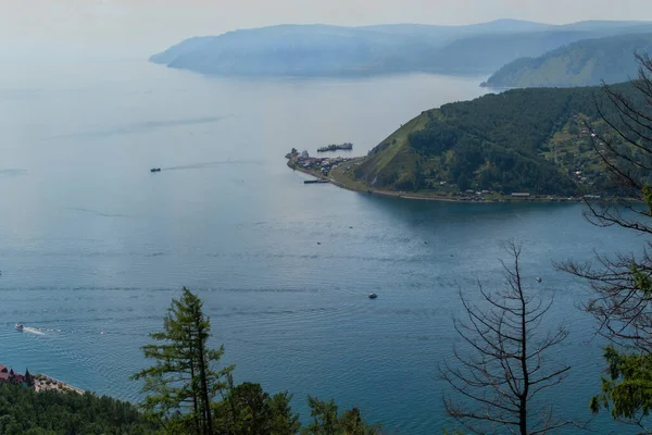 Mavi Baykal Körfezi yakınlarındaki kayaların tepesindeki yeşil dağlar. Chersky Taşı 'ndan Angara Nehri' nin ağzı. Baykal Limanı.