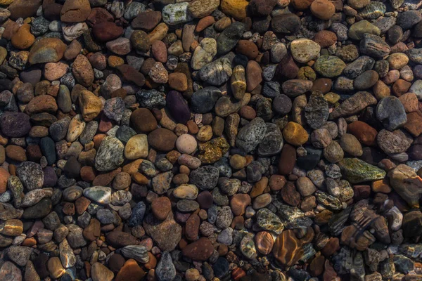 parlak renkli mavi altın küçük çakıl taşları berrak su, güneşte parlıyor, baykal gölü