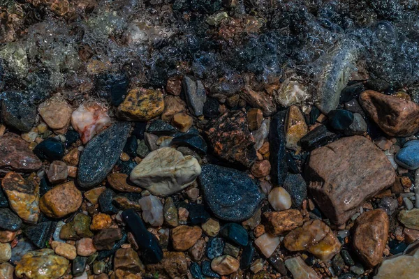 parlak renkli mavi altın küçük çakıl taşları berrak su, güneşte parlıyor, baykal gölü