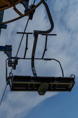 Eski teleferik inşaat koltuğu, güneşli yaz mavi gökyüzü beyaz bulutlu