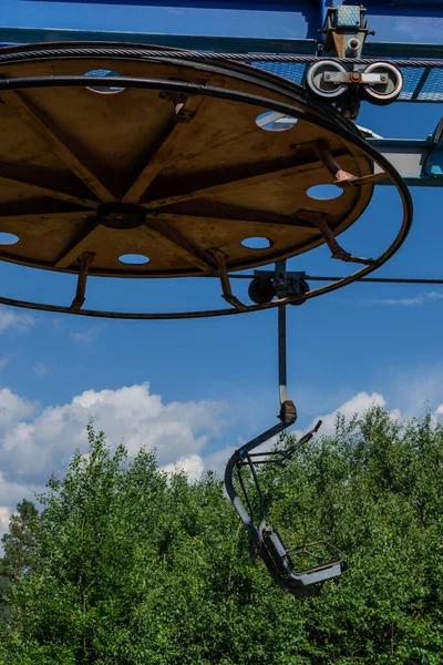Eski teleferik yuvarlak çember inşaatı ormanda koltuklu güneşli yaz mavi gökyüzü beyaz bulutlu