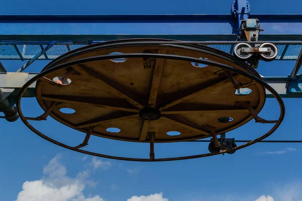 Eski teleferik yuvarlak, paslı bina, güneşli mavi bulutlu gökyüzü.