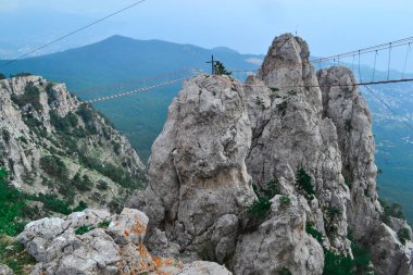 Ukrayna, Kırım 'daki Ai-Petri Dağı' nda ip köprüsü olan kayanın havadan görünüşü. Kırım 'ın en yüksek dağları ve seyahat cazibesi. Uçurumun üzerinde asılı köprü