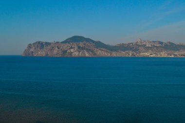 Tepeli güzel kayalık bir pelerin ve mavi zümrüt suyla Karadeniz 'de yüksek dağlar. Kırım, yaz manzarası