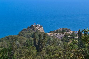 Karadeniz körfezi kıyısındaki inşaatın en üst görüntüsü mavi su, yaz, yeşil orman, ön planda ağaçlar, güneş ışığı