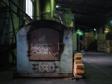 Orman topaklarının üretimi. Ekipmanların yakın plan fotoğrafı. Ahşap endüstrisi: testereli kereste basmak ve kesmek için makine ve ekipman. Metal fırın