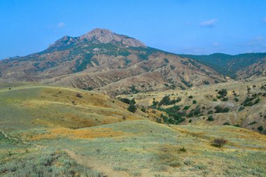 Yeşil tepeli güzel vadiler, yeşil çimenler, yeşil ağaçlar, yüksek dağ sıraları, hava sisli tepeler, yaz mavi gökyüzü, Kırım manzarası, Dünya üzerinde eşsiz bir yer.