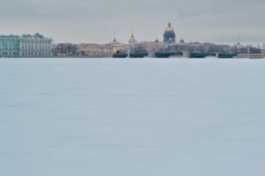St. Petersburg 'da kış seti, temiz renkli binalar ve donmuş Neva nehrinin kıyısındaki St. Isaac Katedrali. Altın kubbeler