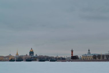 Saint Petersburg 'da kış seti, temiz renkli binalar ve donmuş Neva nehrinin kıyısındaki St. Isaac Katedrali. Avrupa şehri. Bulutlu