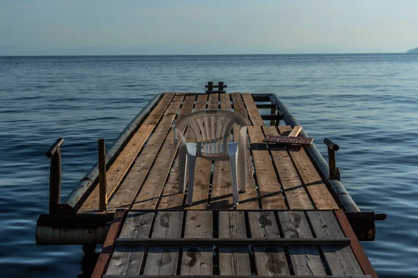 Cadeira Plástico Branco Senta Doca Madeira Pelo Mar Calmo Azul — Fotografia de Stock