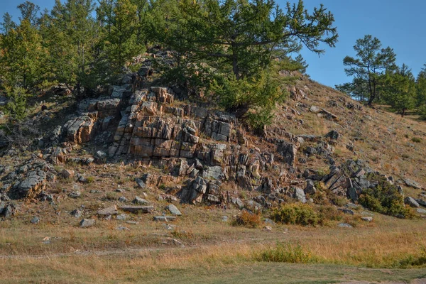 Kamienie Skały Czerwonym Mchem Wzgórzu Pokryte Zieloną Żółtą Trawą Drzewami — Zdjęcie stockowe