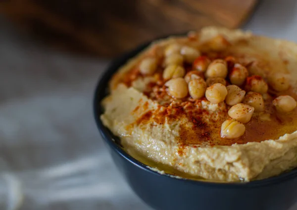 Creamy Hummus Chickpeas Red Spices Dark Bowl Light Kitchen Close — Stock Photo, Image