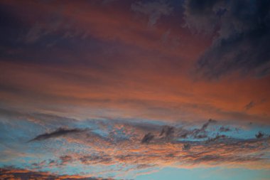 Gün batımında açık mavi gökyüzü pembe turuncu ince bulutlar, yüksek sirokümülüs ve kara bulutlar