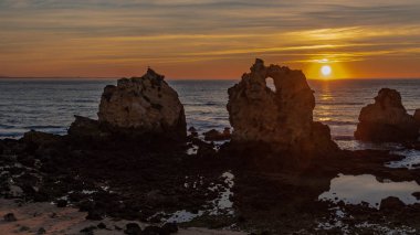 Albufeira, Portekiz 'deki Arrifes Sahili' nde gün doğumunda kayalar.