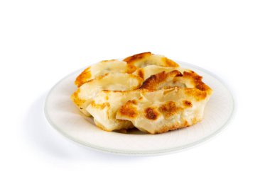 Hamur köfteleri kızartma yağıyla kaplı bir tavada kızartılmış ve bir tabakta servis edilmişti..