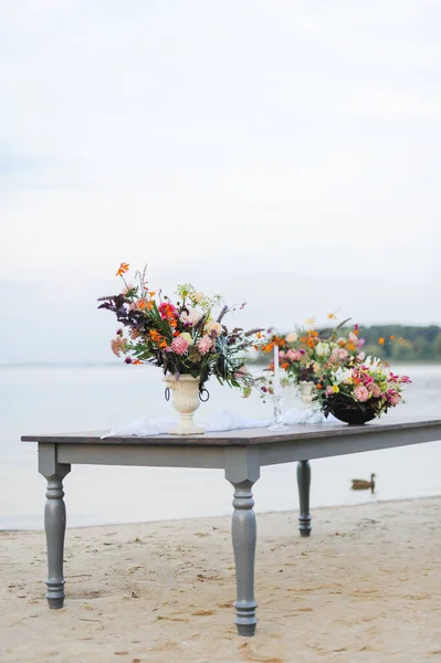 wooden table on the nature.Stylish wedding flower decor. wedding flowers on the table