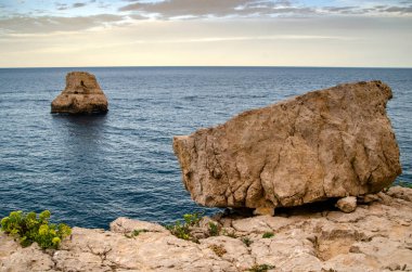 Gün batımında bir uçurumdan deniz manzarası