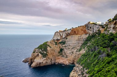 Gün batımında bir uçurumun tepesindeki lüks evler..