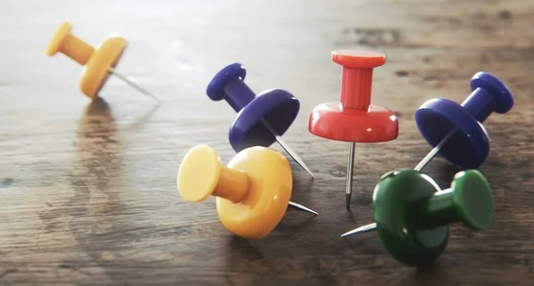 Collection of various color push pins or paper pins on a wooden table, Closeup of push pins