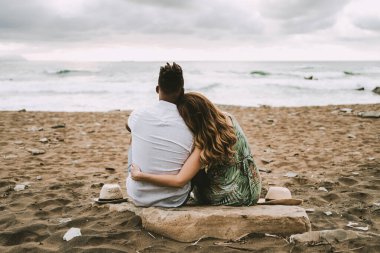 Sahilde sarılan hamile, ırklar arası bir çift.