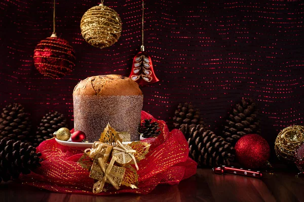 Tüm panettone kırmızı tülle kaplanmış, arka planda kırmızı ışıklar var. Boşluğu kopyala .