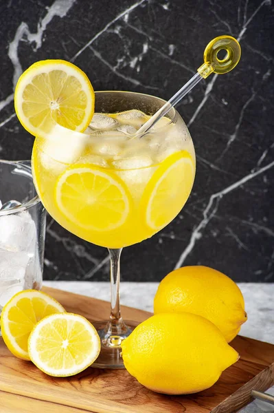Ahşap bir masanın üzerinde bardakta limoncello kokteyli, mermer arka plan..