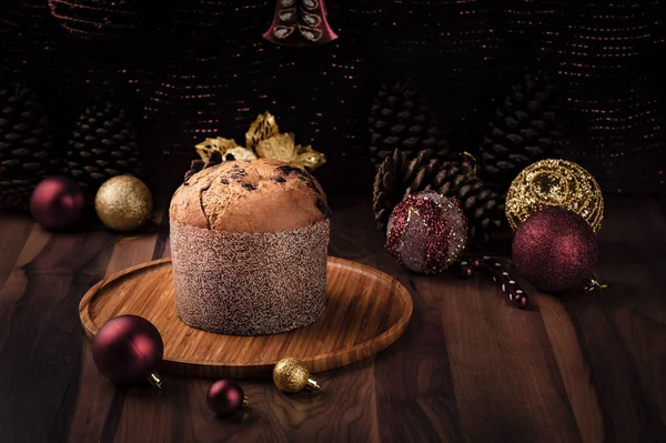 Ahşap tepside Panettone Noel süslemeleriyle çevrili. Bulanık arkaplan, kopyalama alanı.