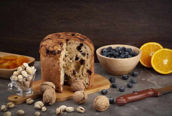 Panettone mutfak tahtasında ve yan tabaklarda rastgele, seçici odak ve kopyalama alanı düzenlenmiş..