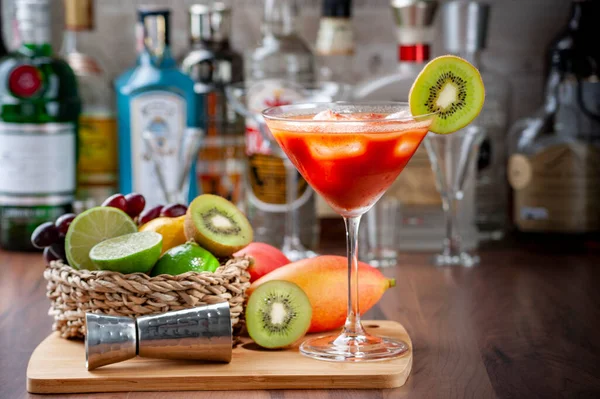 Barın tezgahında, ahşap bir tepside domates suyu. Bulanık arkaplan etrafında bazı meyveler, kopyalamak için boşluk.