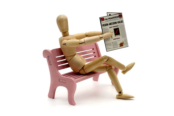 MANIKINS ON BENCH IN RELAX WITH VISION MISSION VALUE NEWSPAPER. USABLE FOR PARK, NEWSPAPER, JOURNALISM, PRESS, NEWS IN GENERAL AND COMPANY STRATEGY.