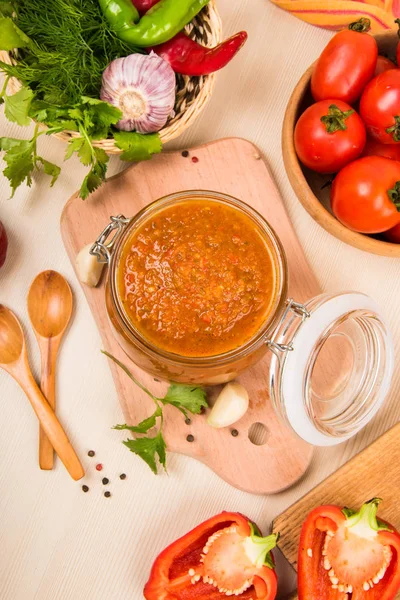 Domates sos (ketçap, adzhika) ve sebze bej bir tablo. Ev koruma.