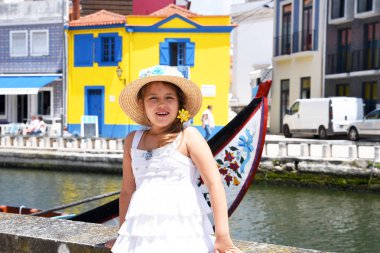 Aveiro, Portekiz. Beyaz elbise ve şapka, küçük bir kız şehrin turistik yerler yürüyor.