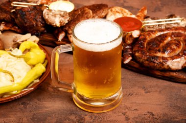 Et Mangal masaya ayarla. Sosis, domuz eti, mantar, sığır eti, sosları, turşu. Bira aperatifler.