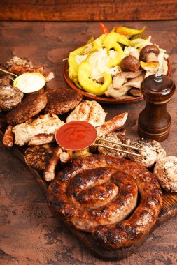 Et Mangal masaya ayarla. Sosis, domuz eti, mantar, sığır eti, sosları, turşu. Bira aperatifler.