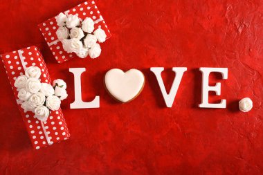 Word aşk ve parlak kırmızı bir arka plan üzerinde bir kalp. yukarıdan görüntüleyin. Metin için yer