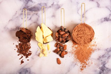 Kakao, kakao yağı ve kakao çekirdekleri, Mermer yüzey üzerinde altın kaplarda çikolata. Düz yatıyordu. Metin için yer.