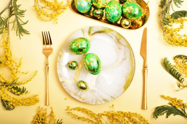 Tablo easter stili ayarında. Mimoza, pişmiş yumurta, altın çatal bıçak takımı boyalı.