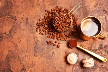 Kahve çekirdekleri, kahverengi arka planda altın fincan kahve.