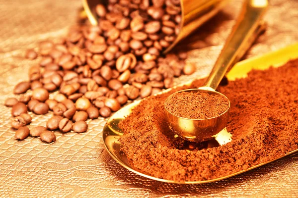 Kahve çekirdekleri, kahverengi arka planda altın fincan kahve.