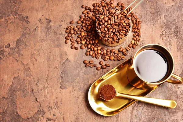 Kaffeebohnen Goldene Tasse Kaffee Auf Braunem Hintergrund — Stockfoto