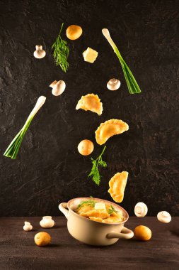 Levitating food. Pierogi. Dumplings with potatoes and mushrooms are flying. Ready meal. clipart