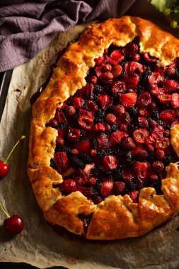 Koyu bir arka plan üzerinde yaz meyveleri ile Galette pasta.