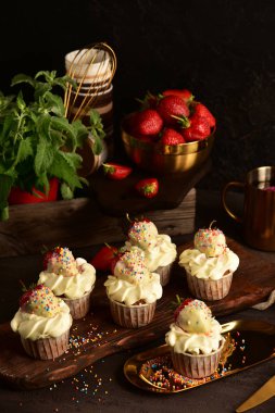 Koyu bir arka plan üzerinde çilek ile Cupcakes. Natürmort