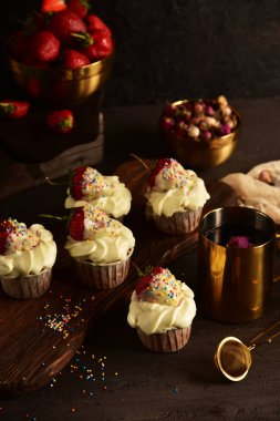 Koyu bir arka plan üzerinde çilek ile Cupcakes. Natürmort