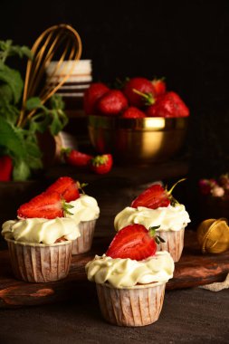 Koyu bir arka plan üzerinde çilek ile Cupcakes. Natürmort