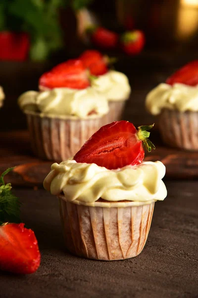 Koyu bir arka plan üzerinde çilek ile Cupcakes. Natürmort