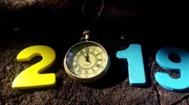 Gece yarısı gösteren bir saat ile sayı 2019.